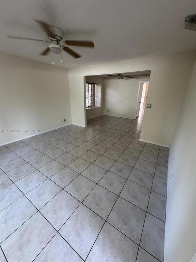 unfurnished room with ceiling fan and light tile patterned floors