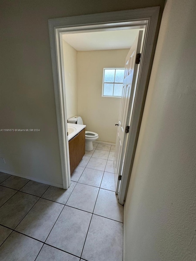 bathroom with tile patterned flooring, vanity, and toilet