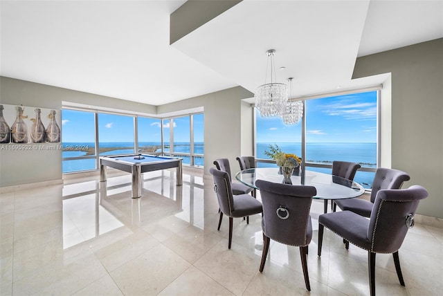 dining area featuring a water view, light tile patterned floors, billiards, and an inviting chandelier