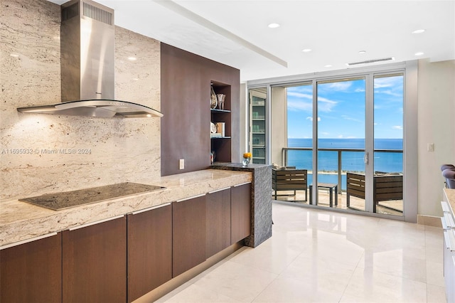 kitchen with black electric stovetop, a water view, wall chimney exhaust hood, tasteful backsplash, and light stone counters