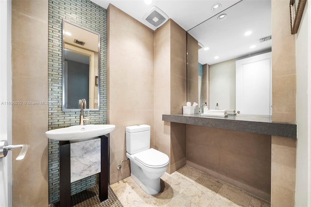 bathroom featuring tile walls and toilet