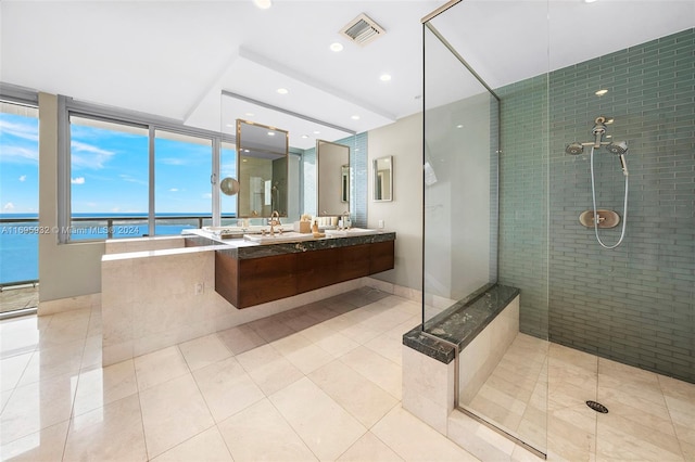 bathroom featuring a water view, tile patterned floors, a shower with door, and sink