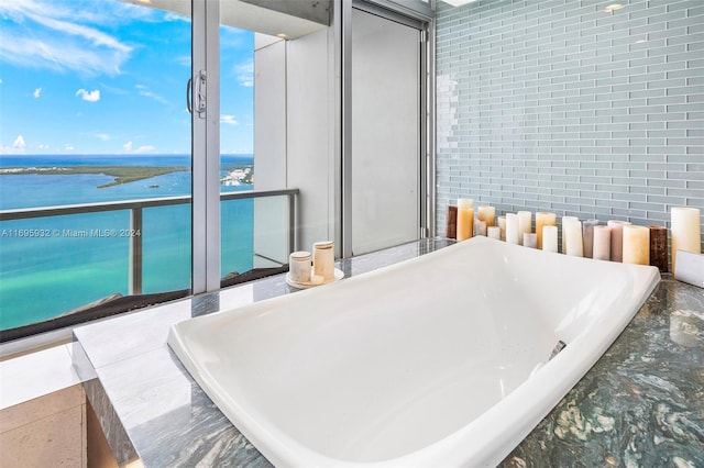 bathroom featuring a water view and brick wall