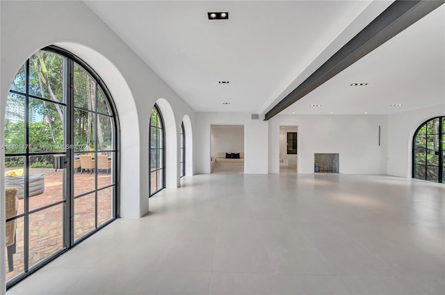 interior space featuring beam ceiling and light tile patterned flooring