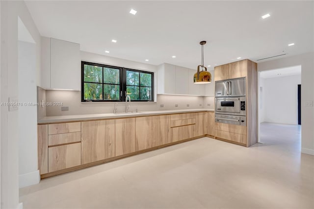 kitchen featuring tasteful backsplash, sink, light brown cabinets, oven, and hanging light fixtures