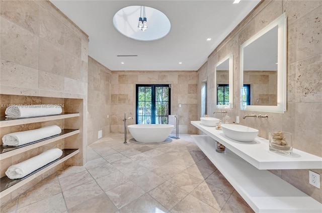 bathroom featuring french doors, vanity, tile walls, and a washtub