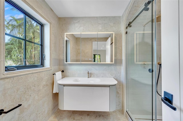 bathroom featuring vanity, an enclosed shower, and tile walls