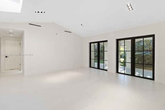 unfurnished room featuring a healthy amount of sunlight, lofted ceiling, and french doors