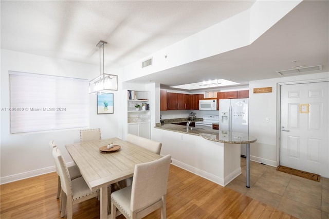 dining area with sink and light wood-type flooring