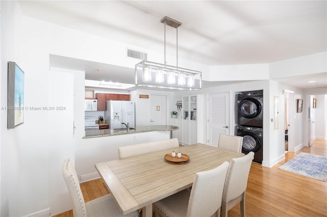 7275 SW 90th St Unit C212, Miami, FL 33156 - dining area with estacked washer and dryer, light wood-style floors, and baseboards