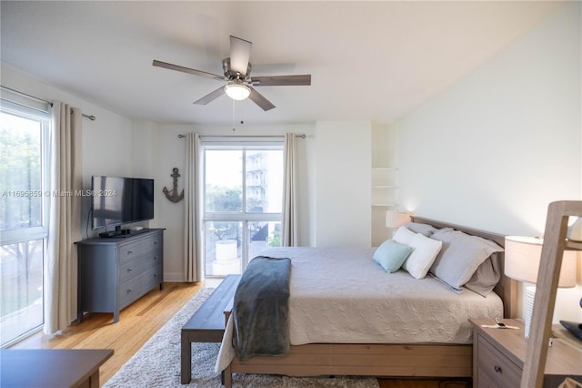 bedroom with access to outside, multiple windows, ceiling fan, and light hardwood / wood-style floors