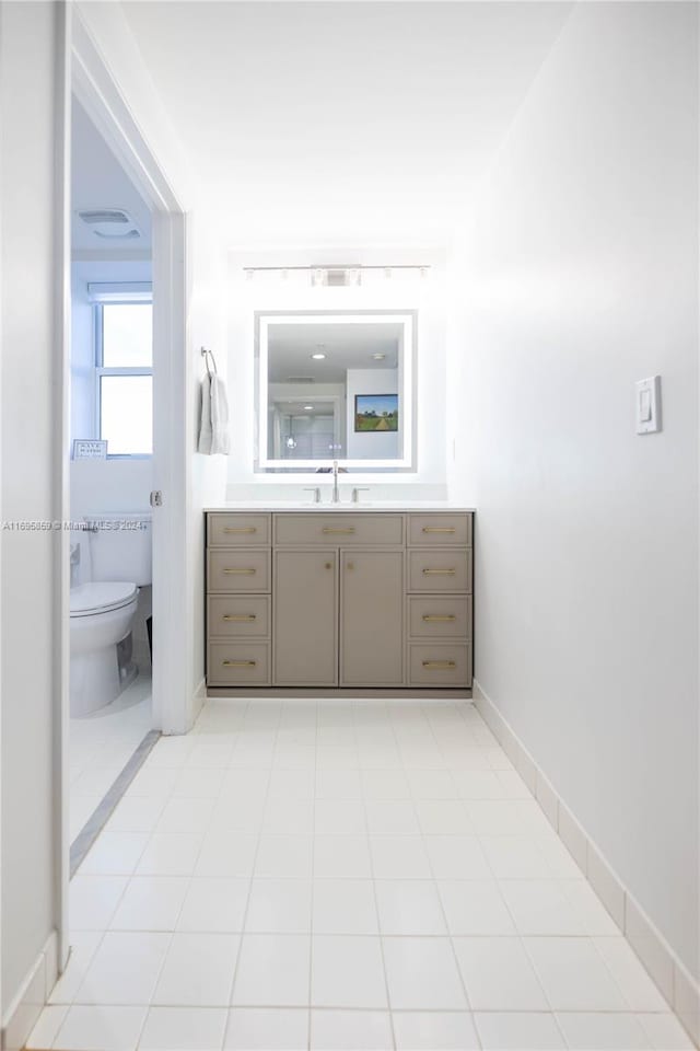 bathroom featuring tile patterned flooring, vanity, and toilet