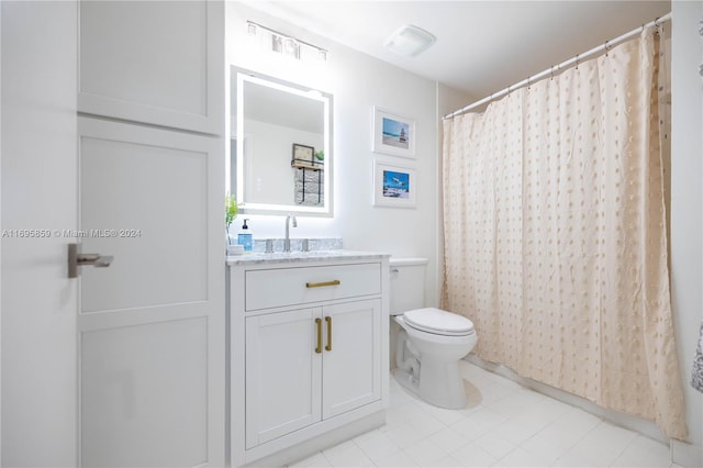 bathroom featuring tile patterned flooring, vanity, and toilet