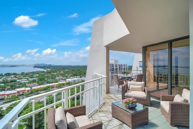 balcony featuring outdoor lounge area and a water view