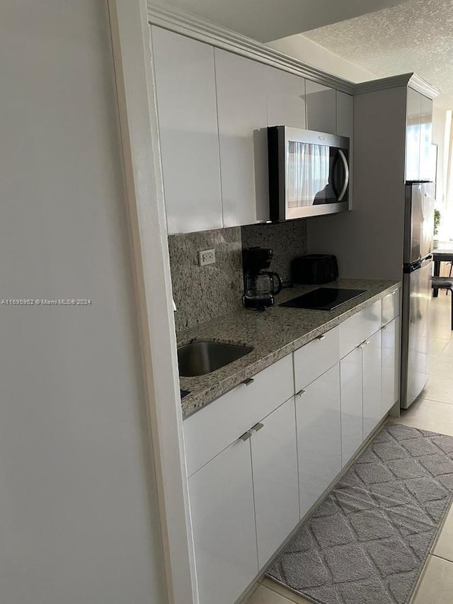 kitchen with white cabinets, light tile patterned floors, and stainless steel appliances