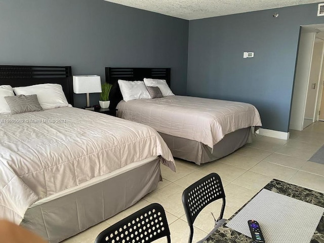 tiled bedroom featuring a textured ceiling