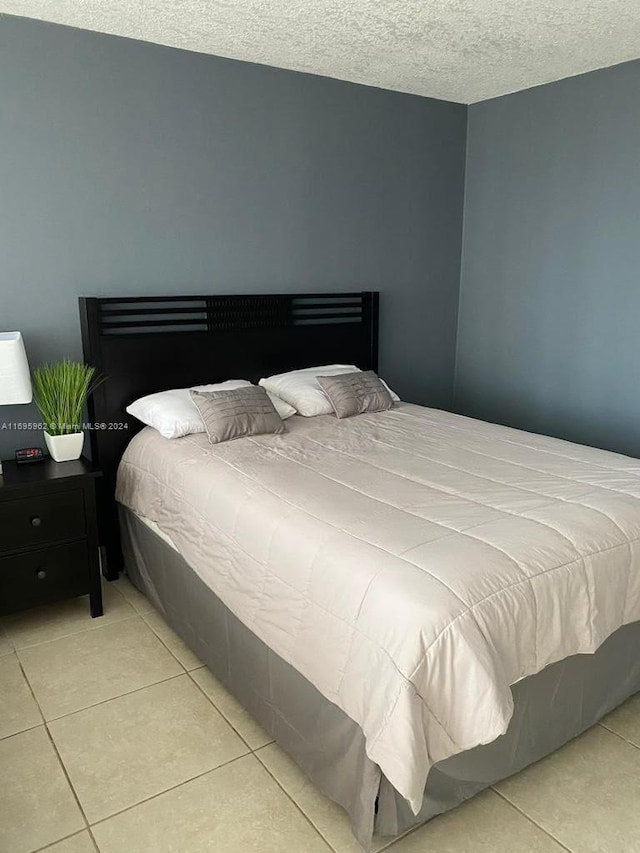 bedroom featuring light tile patterned flooring and a textured ceiling