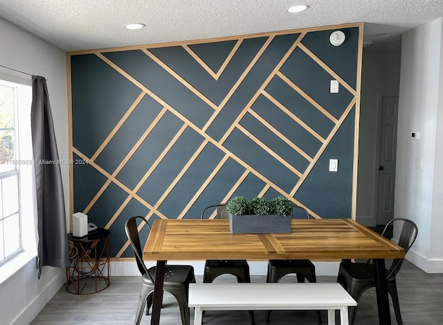 dining space with hardwood / wood-style floors and a textured ceiling