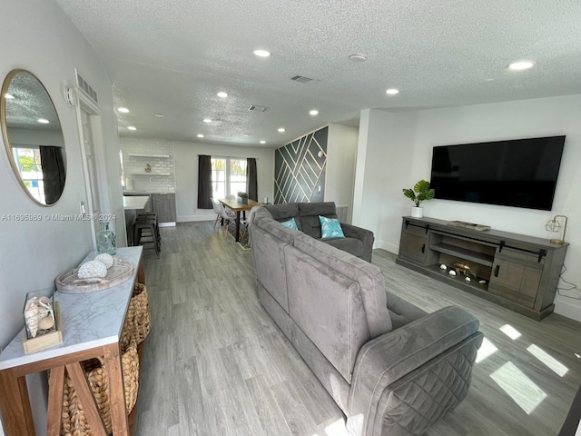 living room featuring a textured ceiling and light wood-type flooring