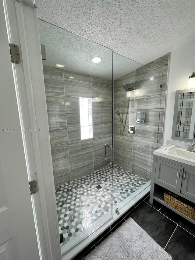 bathroom featuring tile patterned floors, vanity, and a shower with shower door