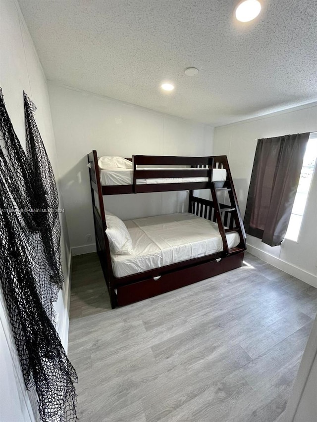 bedroom with hardwood / wood-style flooring and a textured ceiling