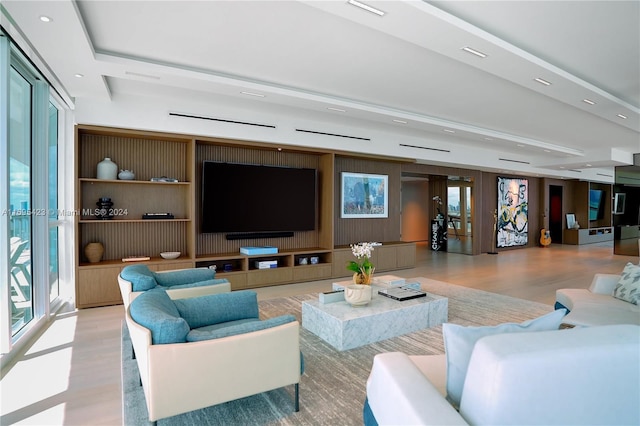 living room featuring french doors, light wood-type flooring, and a healthy amount of sunlight