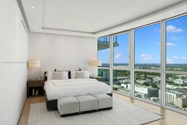 bedroom featuring hardwood / wood-style floors, expansive windows, and access to exterior