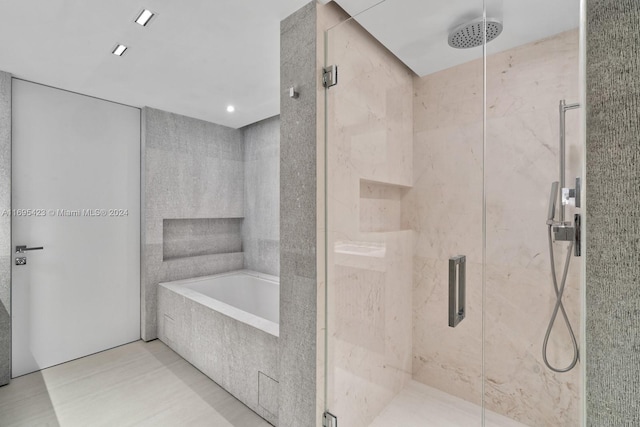 bathroom featuring tile patterned flooring and shower with separate bathtub