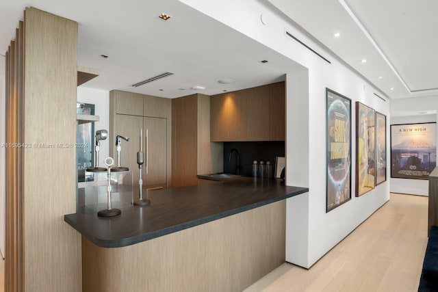 101 20th St Unit 3503/06/09, Miami Beach, FL 33139 - kitchen featuring dark countertops, modern cabinets, light wood-style floors, a peninsula, and recessed lighting