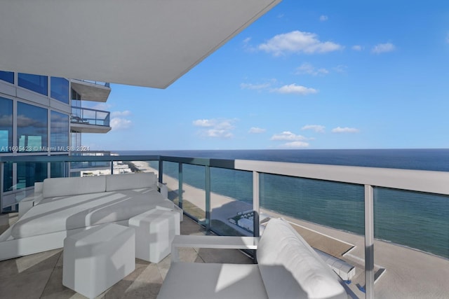 balcony with a water view and a view of the beach