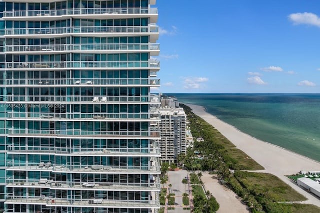 view of building exterior with a water view and a view of the beach