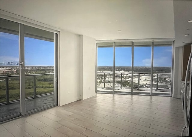 spare room with hardwood / wood-style floors, plenty of natural light, and floor to ceiling windows