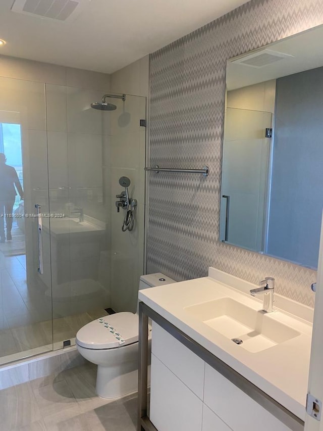 bathroom with vanity, toilet, an enclosed shower, and tile walls