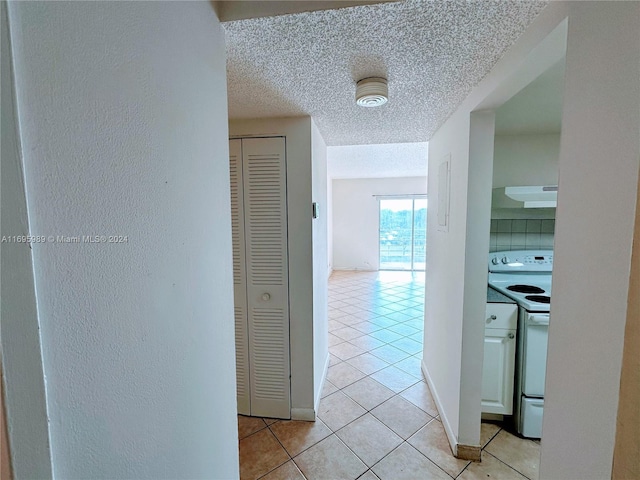 hallway with light tile patterned floors and a textured ceiling