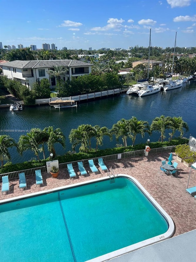 view of pool with a water view and a patio area