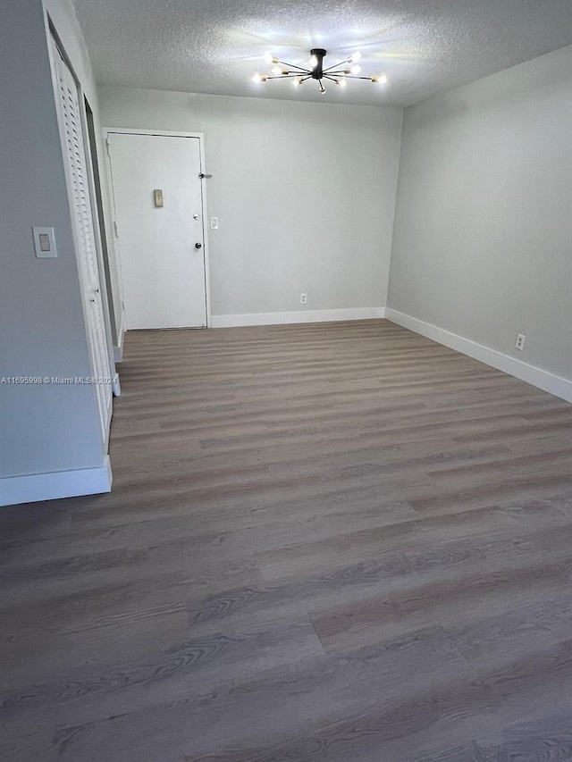 401 Golden Isles Dr Unit 303, Hallandale Beach, FL 33009 - empty room with baseboards, wood finished floors, and a textured ceiling