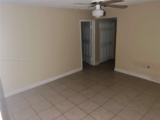 tiled spare room with ceiling fan