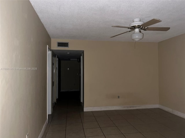 tiled empty room featuring a textured ceiling and ceiling fan