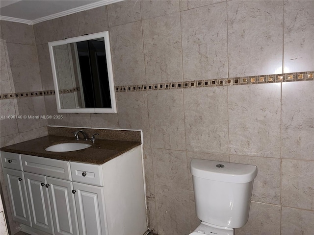 bathroom featuring tile walls, crown molding, vanity, and toilet