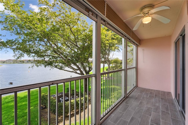 balcony with a water view and ceiling fan