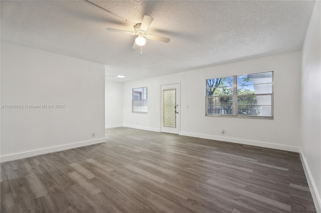 unfurnished room with ceiling fan, dark wood-type flooring, and a textured ceiling