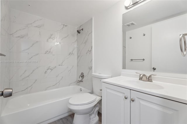 full bathroom with hardwood / wood-style flooring, tiled shower / bath combo, toilet, and vanity