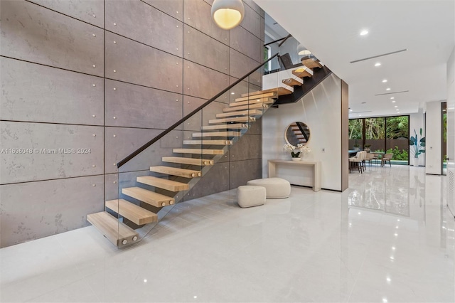 stairs featuring tile patterned floors and a wall of windows