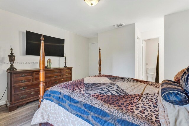 bedroom with connected bathroom and light hardwood / wood-style flooring