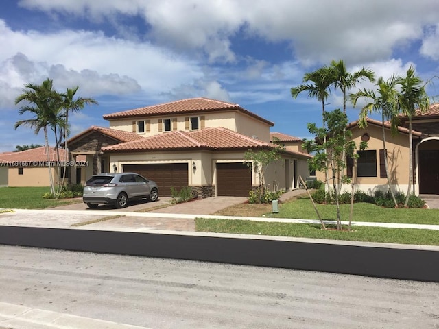 mediterranean / spanish house with a garage and a front lawn