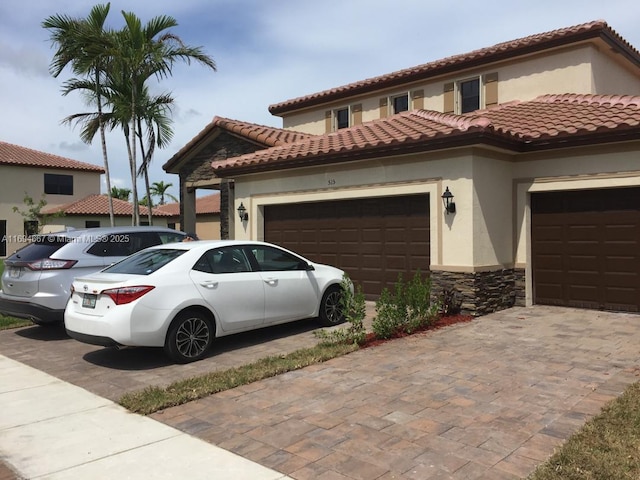 515 SE 35th Ave, Homestead, FL 33033 - mediterranean / spanish home with stucco siding, an attached garage, stone siding, decorative driveway, and a tile roof