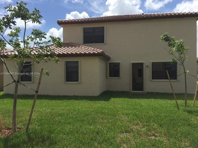 rear view of property featuring a yard