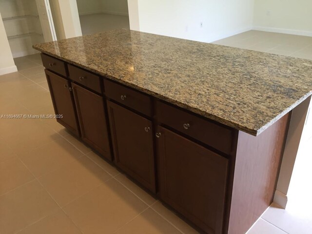 515 SE 35th Ave, Homestead, FL 33033 - kitchen with stone countertops, dark brown cabinetry, light tile patterned flooring, and a center island