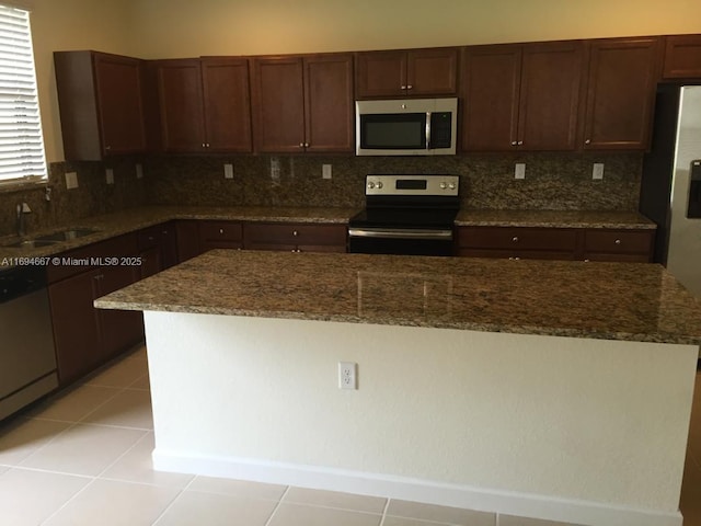 515 SE 35th Ave, Homestead, FL 33033 - kitchen with stainless steel appliances, a sink, backsplash, and dark stone counters