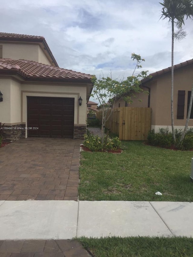 view of property exterior featuring a garage and a lawn